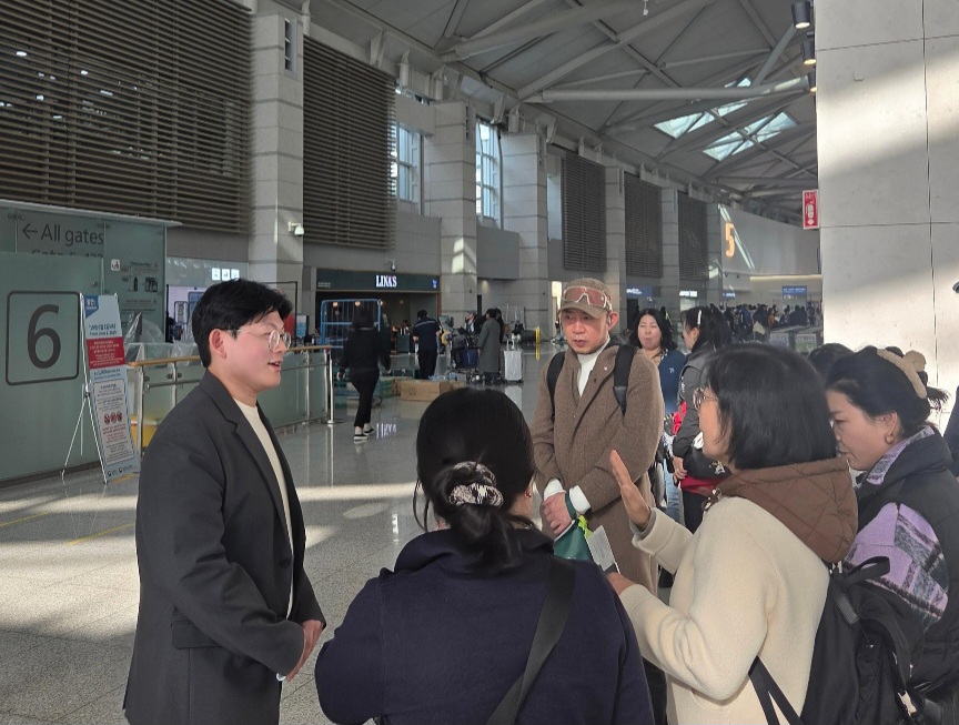 인천공항에서 단체 손님에게 안내 중인 여행한잔