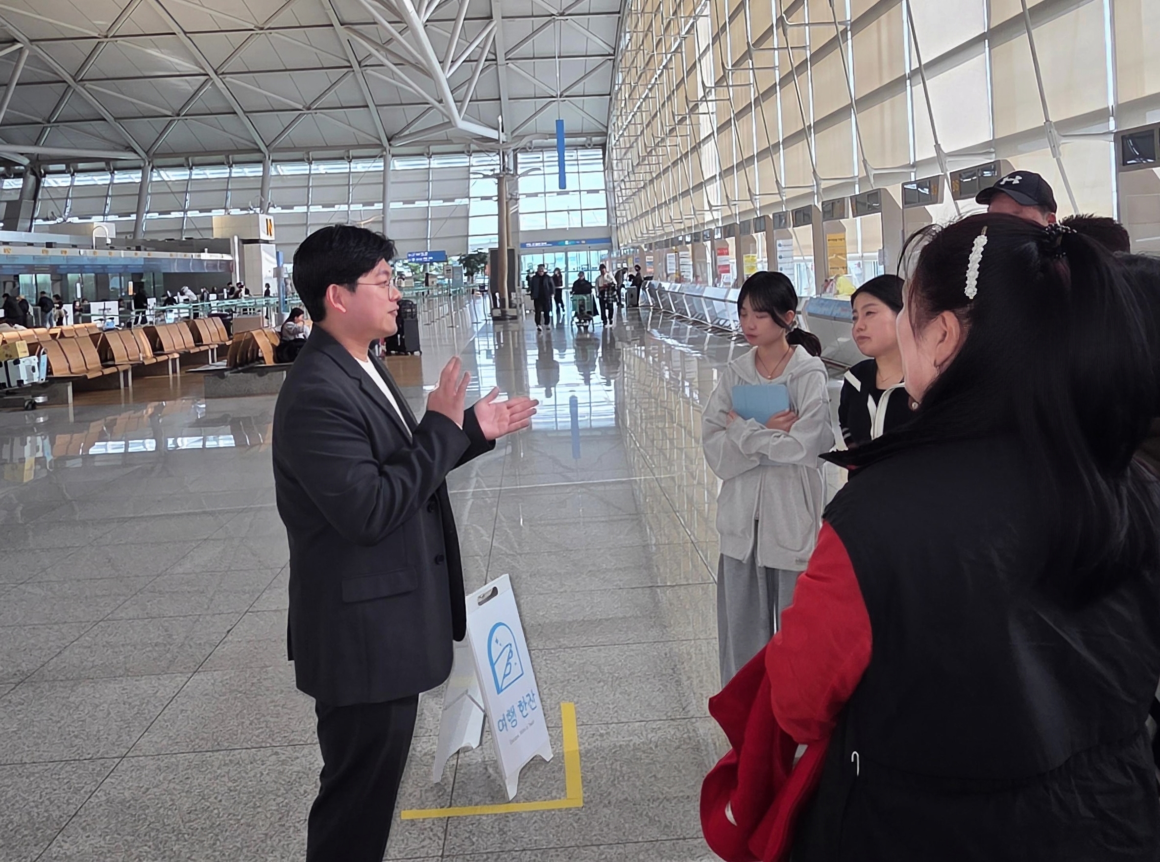 인천공항에서 단체 손님에게 안내 중인 여행한잔